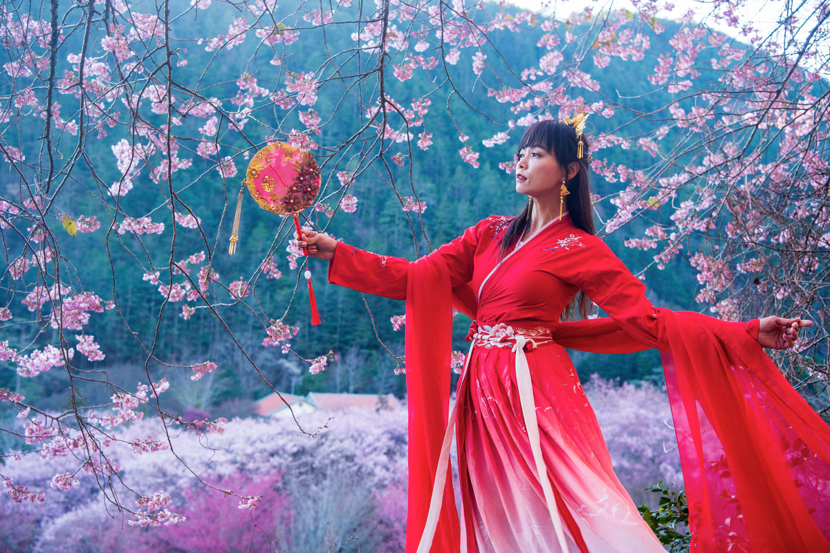 A woman in a red dress flaunting Chinese jewelry.