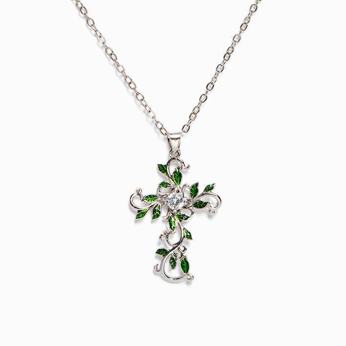 Leaf necklace on white background, close-up of the leafy cross pendant.
