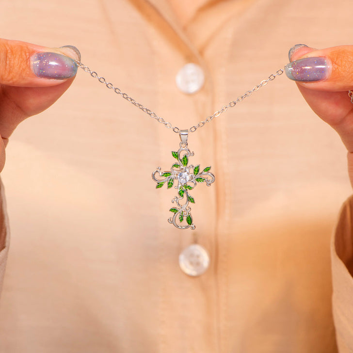 Detailed close-up of the leafy cross design and engraving on the leaf necklace.