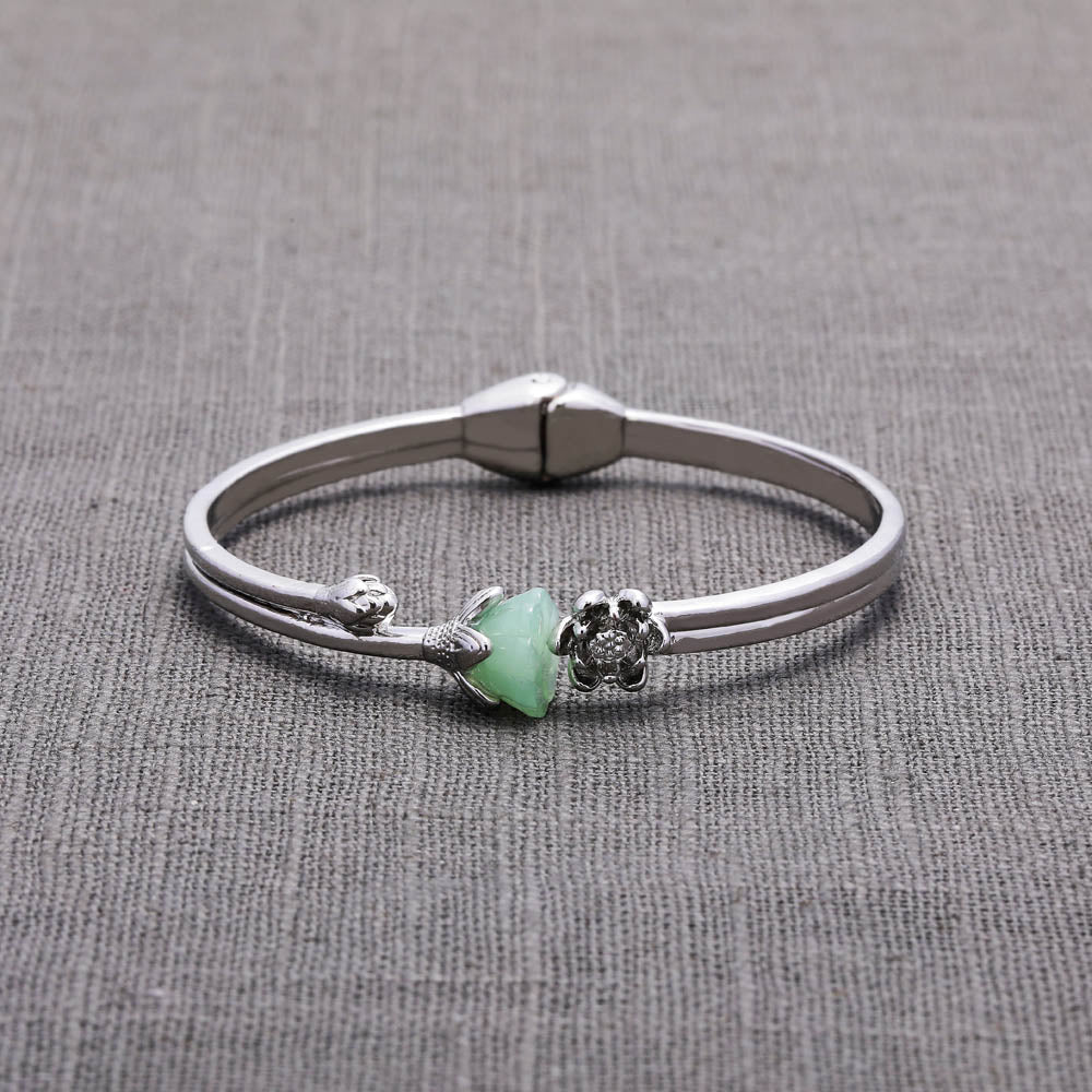 Close-up detail of jade lotus charm and bracelet