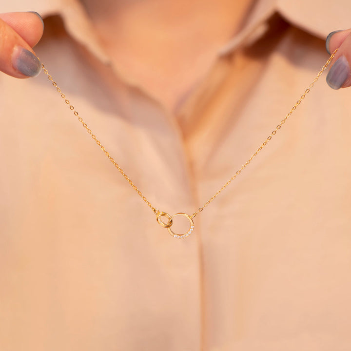 Close-up view of double ring necklace for granddaughter, highlighting intricate craftsmanship and engraved details.