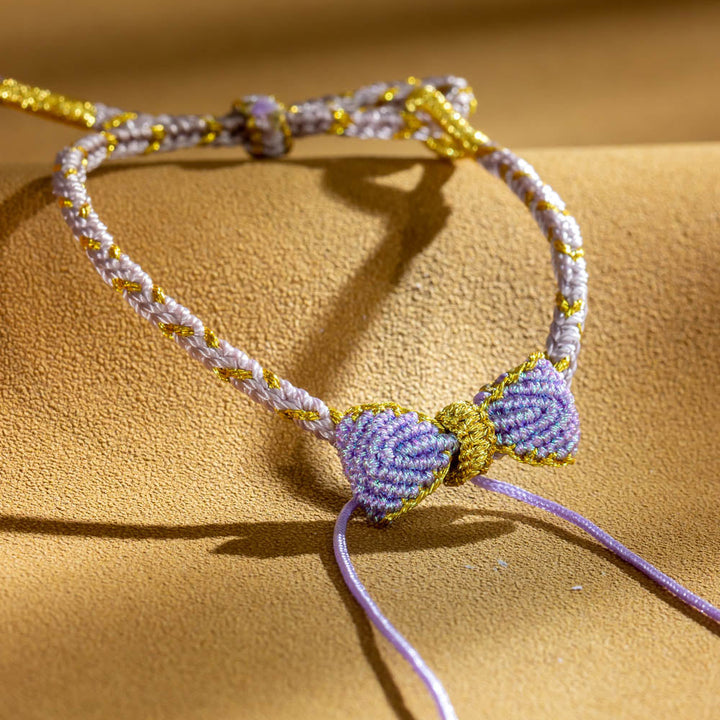 Knitted bowknot bracelet with an inspirational message. Perfect for wishing luck and support. The image depicts a stylish bracelet adorned with a bowknot, symbolizing encouragement and well-wishes for the wearer's journey